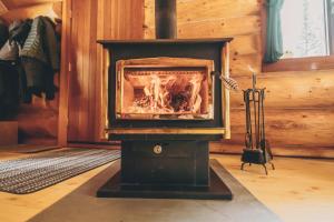 a woodburning stove in a room with a fireplace at Rocky Mountain Escape Log Cabin Rentals - Rock Lake in Rock Lake Lodge Provincial Park