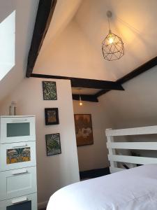 Un dormitorio con una cama blanca y una escalera en Grade I listed luxury apartment in Hertfordshire en Ware