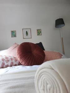 un letto con un grande cuscino rosso sopra di Grade I listed luxury apartment in Hertfordshire a Ware