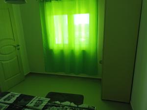 a room with a green curtain and a window at Apartmani Bella in Sutomore