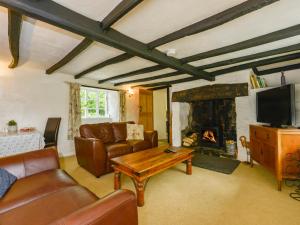 un salon avec un canapé et une cheminée dans l'établissement Little Week Cottage, à Bridestowe