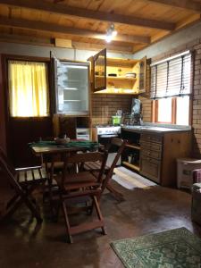 een keuken met een tafel en stoelen en een fornuis bij Chalé Koch in Visconde De Maua