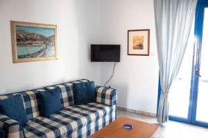 a living room with a couch and a tv at Hara's Studio in Perdika