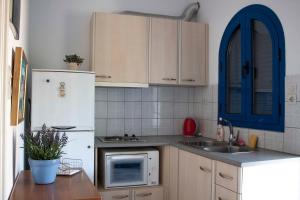 a kitchen with a white refrigerator and a sink at Hara's Studio in Perdika