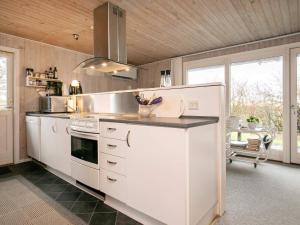 a kitchen with white cabinets and a stove at Holiday home Bogense XXXIII in Bogense