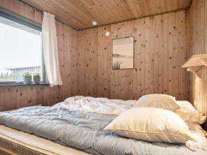a bed in a room with a wooden wall at Holiday home Bogense XXXIII in Bogense