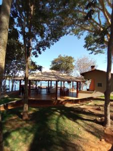 a pavilion with tables and trees in a park at Flat Pontal do Lago in Caldas Novas
