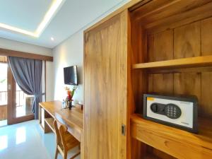 a hotel room with a desk and a microwave at Surawan Bisma Ubud in Ubud