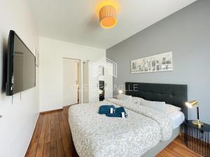 ein Schlafzimmer mit großem Bett und Flachbildfernseher in der Unterkunft Appartement Coeur de Deauville in Deauville