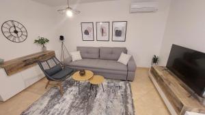 salon z kanapą, stołem i telewizorem w obiekcie NewTown Apartment w mieście Novigrad