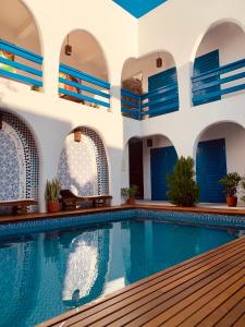 a swimming pool in a house with blue doors at Casa boa vida in Jericoacoara