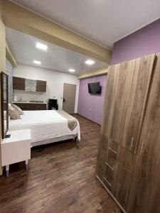 1 dormitorio con 1 cama y TV. en Villa Las Flores en San Salvador