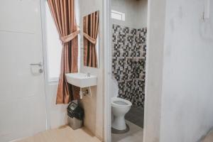 RUMAH KOPI SYARIAH HOTEL في بندر لامبونغ: حمام مع مرحاض ومغسلة