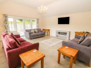 a living room with two couches and a tv at Ochr Y Garth in Llanrwst