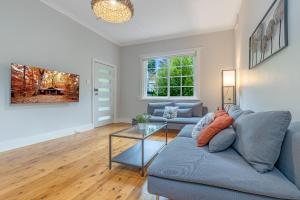 a living room with a blue couch and a glass table at Sunshine Cottage in Katoomba
