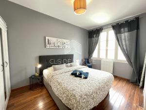 ein Schlafzimmer mit einem Bett mit einer weißen Tagesdecke in der Unterkunft Appartement Coeur de Deauville in Deauville