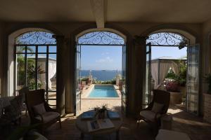 a house with a view of a swimming pool through the windows at Villa Caprichosa in Taboga