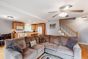 a living room with a couch and a ceiling fan at Sheldrake Cove Retreat in Windham