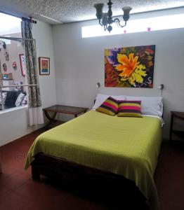 Un dormitorio con una cama verde con una pintura en la pared en SANITIZED - APARTMENT - Metropolitan Quito Area Eng - Fr - Esp, en Quito