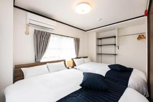 two beds sitting next to each other in a bedroom at Vacation Rental NISHIDA in Kagoshima