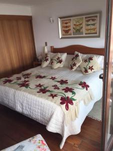 a bedroom with a large bed with a floral bedspread at Depto playa amarilla ConCon in Concón +11 photos