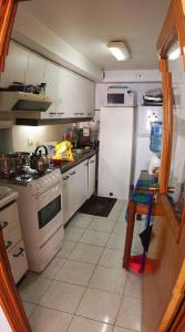 a kitchen with white appliances and a white refrigerator at Depto playa amarilla ConCon in Concón
