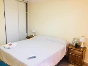 1 dormitorio con 1 cama blanca y 2 mesitas de noche en Complejo Nazareno en San Juan