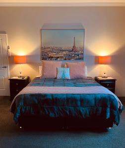 a bedroom with a large bed with a picture on the wall at Gundaroo Manor Bed & Breakfast in Gundaroo