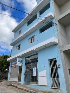 ein blau-weißes Gebäude mit einem Fenster in der Unterkunft Apartamento Elite em Cunha in Cunha