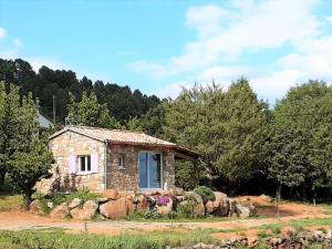 mały kamienny dom na polu z drzewami w obiekcie Stone House in France with Pool & Vineyards w mieście Chambonas