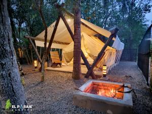 a tent with a fire in front of a fire pit at El Paraje Camping in Piribebuy