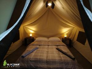 um quarto com uma cama numa tenda em El Paraje Camping em Piribebuy