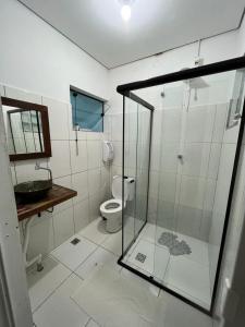 a bathroom with a glass shower and a toilet at Hospedagem Elite térreo in Cunha +53 photos