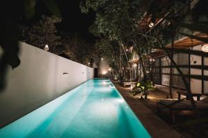 a swimming pool in a house at night at Unique & Stylish Apartment With Lovely Decked Terrace & Awesome Floating Pool In Tulum in Tulum