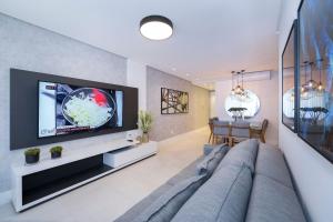 TV a/nebo společenská místnost v ubytování Adra 105 - Excelente apartamento no centro de Bombinhas - Rooftop com piscina e academia - À poucos metros da praia - (Consultar serviços de roupas de cama e banho)