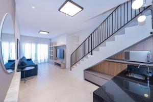 a living room with a staircase in a house at Adra 306 - Excelente Cobertura Duplex - Centro/Bombinhas- Rooftop com Piscina - À poucos metros da praia - (Consultar serviços de roupas de cama e banho) in Bombinhas