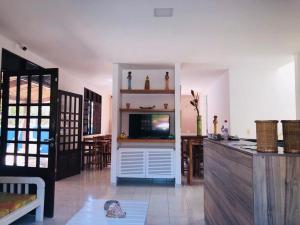 un salon avec une télévision à écran plat dans une chambre dans l'établissement Suites Areias de Porto, à Porto de Galinhas