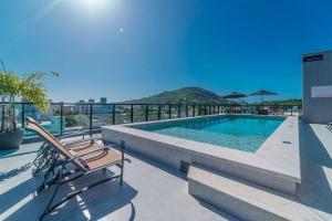 ein Swimmingpool auf einem Gebäude in der Unterkunft Adra 103 - Apartamento no centro de Bombinhas - Rooftop com piscina e academia - À poucos metros da praia - (Consultar serviços de roupas de cama e banho) in Bombinhas