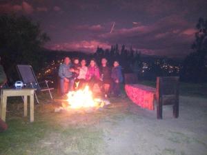 a group of people sitting around a fire at night at Fundo San Silvestre in Huaraz