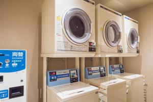 a laundry room with four washing machines on display at Hotel Grand View Takasaki in Takasaki