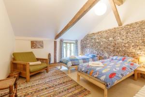 ein Schlafzimmer mit einem Bett und einem Stuhl in der Unterkunft Colemans Farm Barn in Braintree