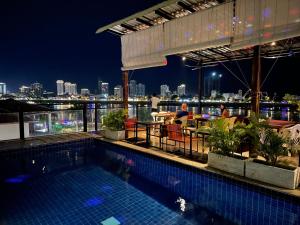 a swimming pool with a view of the city at night at Onederz Hostel Phnom Penh in Phnom Penh