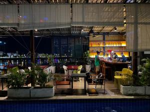 a restaurant with a bar and a man standing in the background at Onederz Hostel Phnom Penh in Phnom Penh