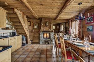 a kitchen with a long table and a fireplace at Chalet Bonheur in La Tzoumaz