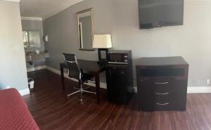 Legacy inn & suites في أنهايم: غرفة مع مكتب مع جهاز كمبيوتر ومرآة