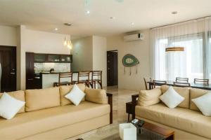 a living room with two couches and a table at Amazing Luxury Penthouse with sunset,sunrise view, private Jacuzzi and rooftop pool in Tulum