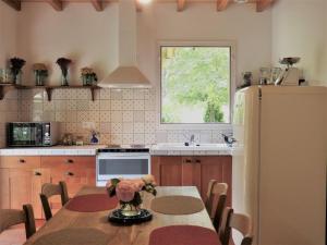 cocina con mesa y nevera en Charming house with private spa, en Duras