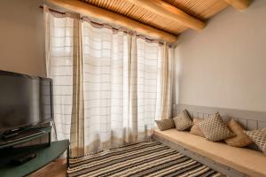 a living room with a couch and a large window at Primrose Cottage, 1 bhk Villa w garden by Roamhome in Leh