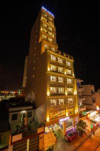 a tall building with lights on it at night at Gem Nha Trang Hotel in Nha Trang