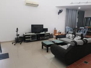 a living room with a couch and a tv at Bp Pool homestay28 in Batu Pahat